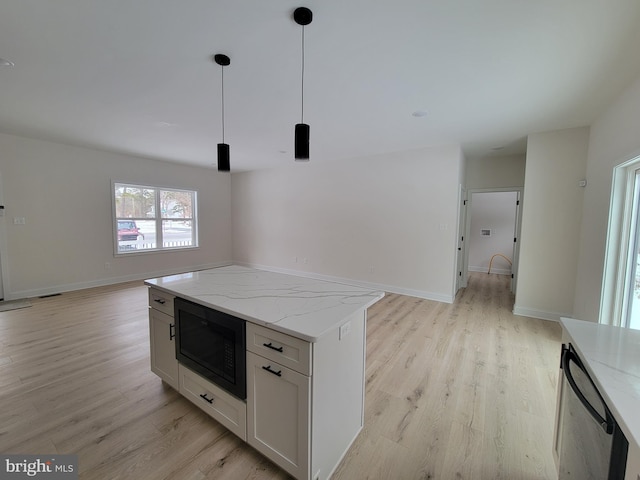 kitchen with light wood-style floors, black microwave, dishwasher, and open floor plan