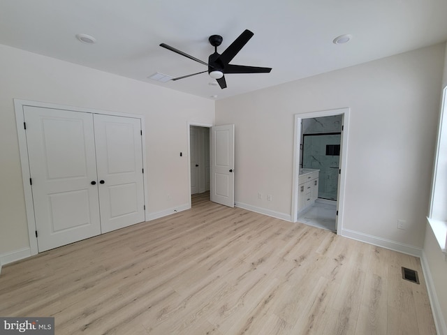 unfurnished bedroom featuring light wood-type flooring, baseboards, visible vents, and a closet