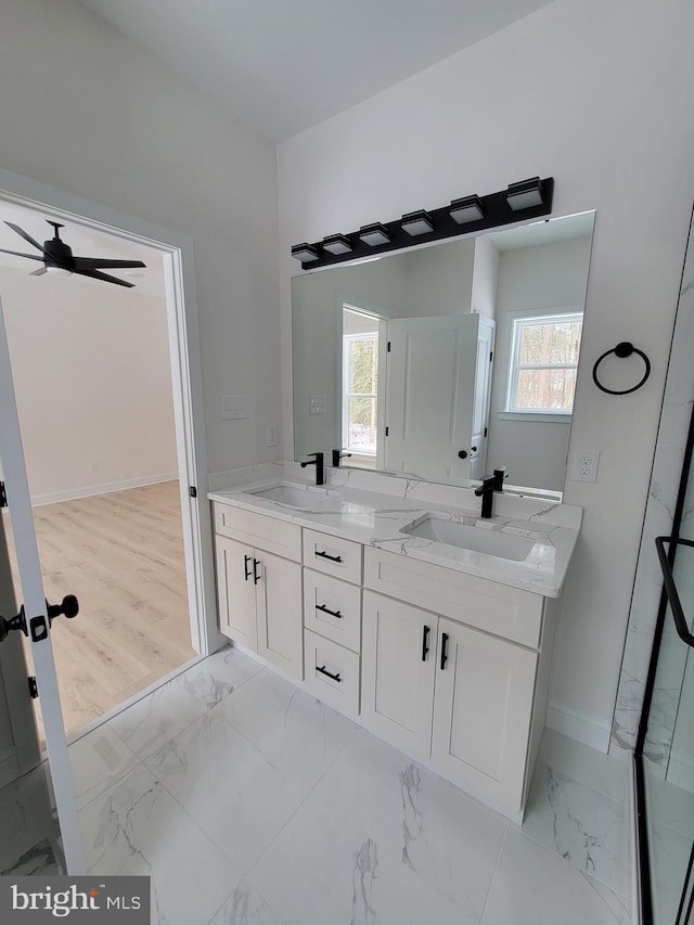 bathroom featuring marble finish floor, a sink, and a healthy amount of sunlight