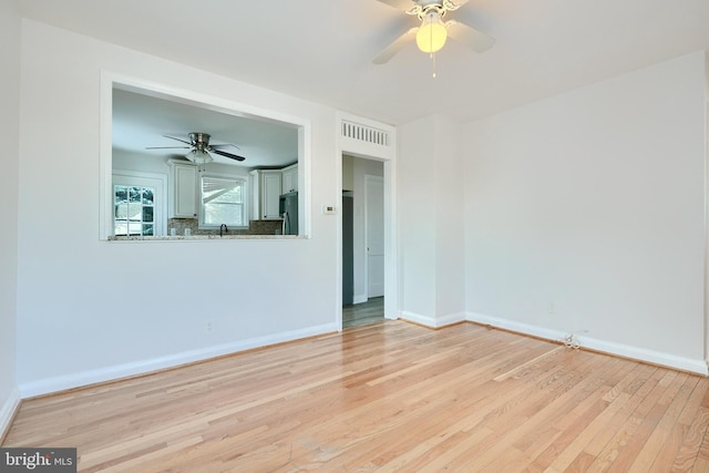 empty room featuring light wood-type flooring and ceiling fan