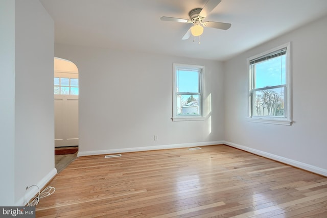 unfurnished room featuring ceiling fan, plenty of natural light, and light wood-type flooring