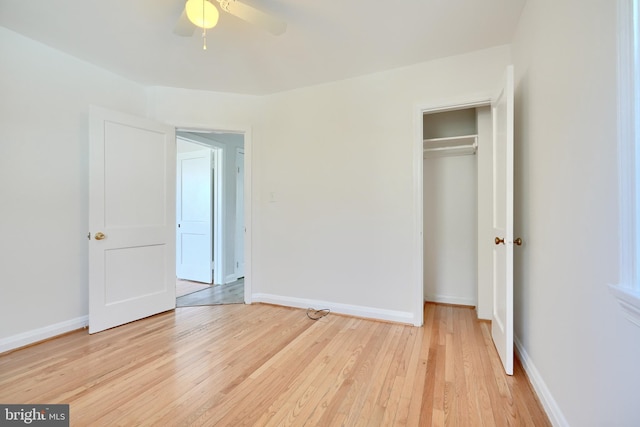 unfurnished bedroom featuring ceiling fan, a closet, and light wood-type flooring