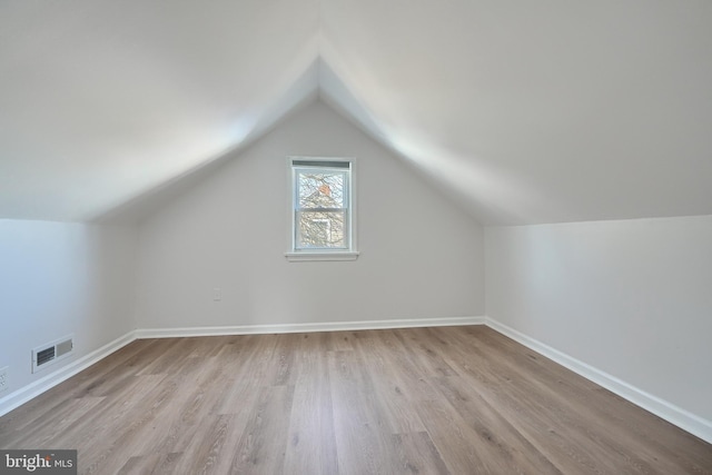 bonus room with light hardwood / wood-style floors and vaulted ceiling