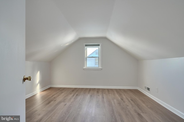 additional living space featuring light hardwood / wood-style flooring and lofted ceiling