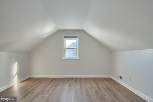 bonus room featuring lofted ceiling and light wood-type flooring