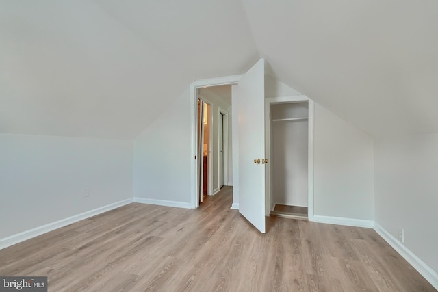 additional living space featuring light hardwood / wood-style flooring and vaulted ceiling