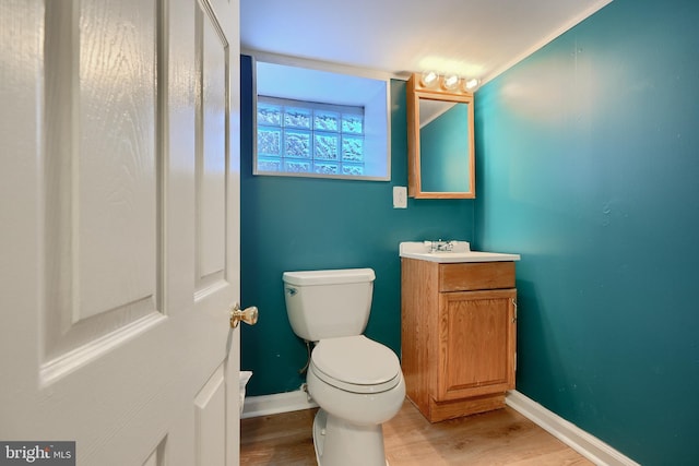 bathroom featuring toilet, hardwood / wood-style floors, and vanity