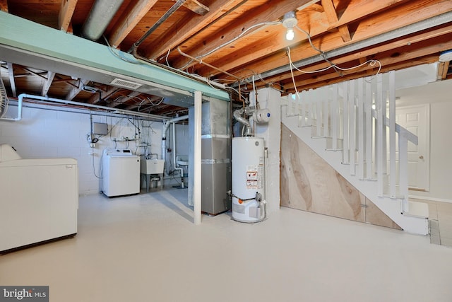 basement with sink, washing machine and dryer, and water heater