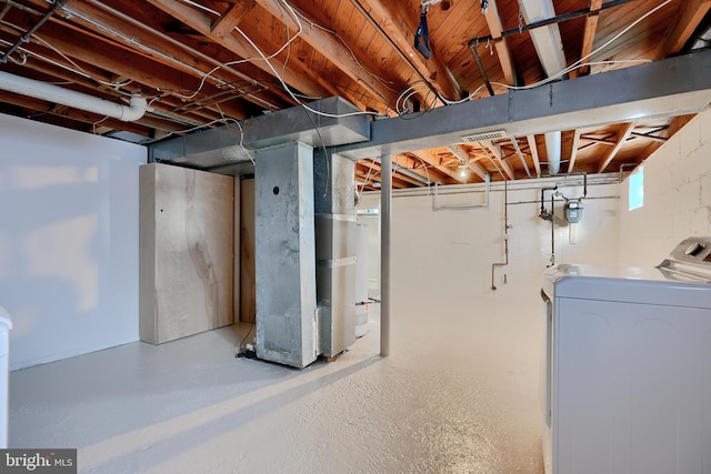 basement featuring heating unit and washer / dryer