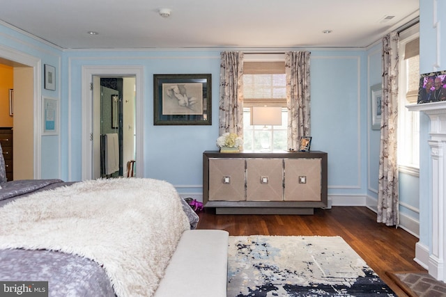 bedroom featuring dark wood finished floors and crown molding