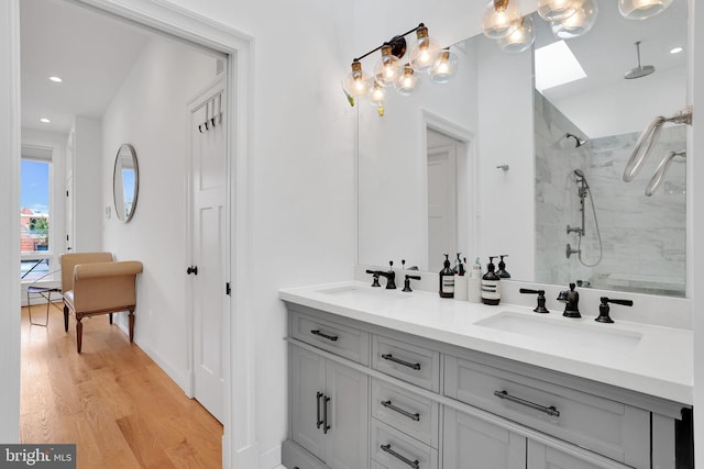 bathroom featuring vanity, hardwood / wood-style flooring, and a tile shower