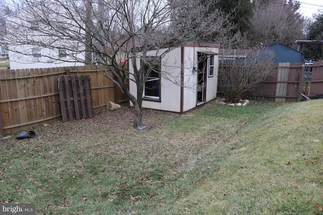 view of yard with an outbuilding, a shed, and a fenced backyard