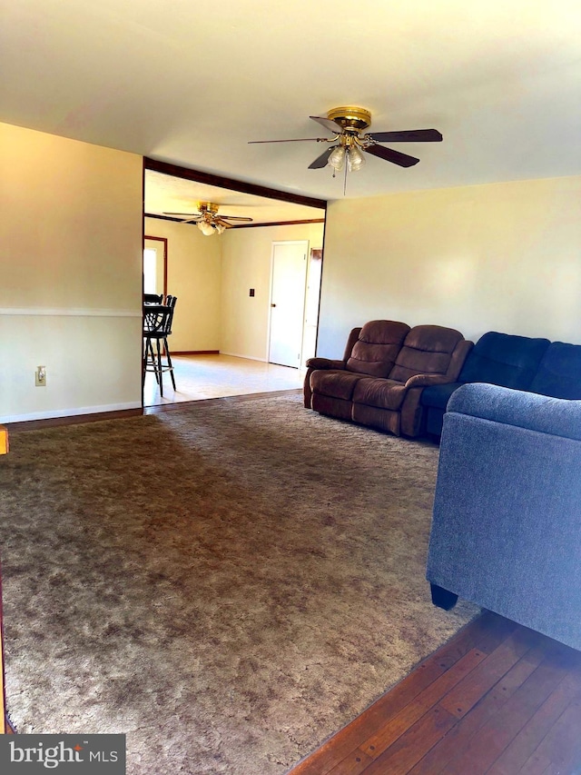 living area with ceiling fan and dark wood finished floors