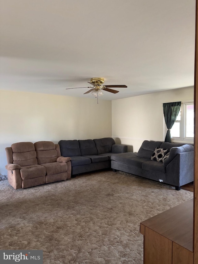 living room with a ceiling fan and carpet