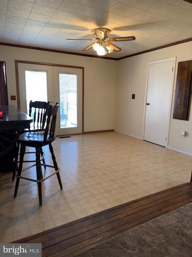 dining space with light wood finished floors, baseboards, ceiling fan, crown molding, and french doors