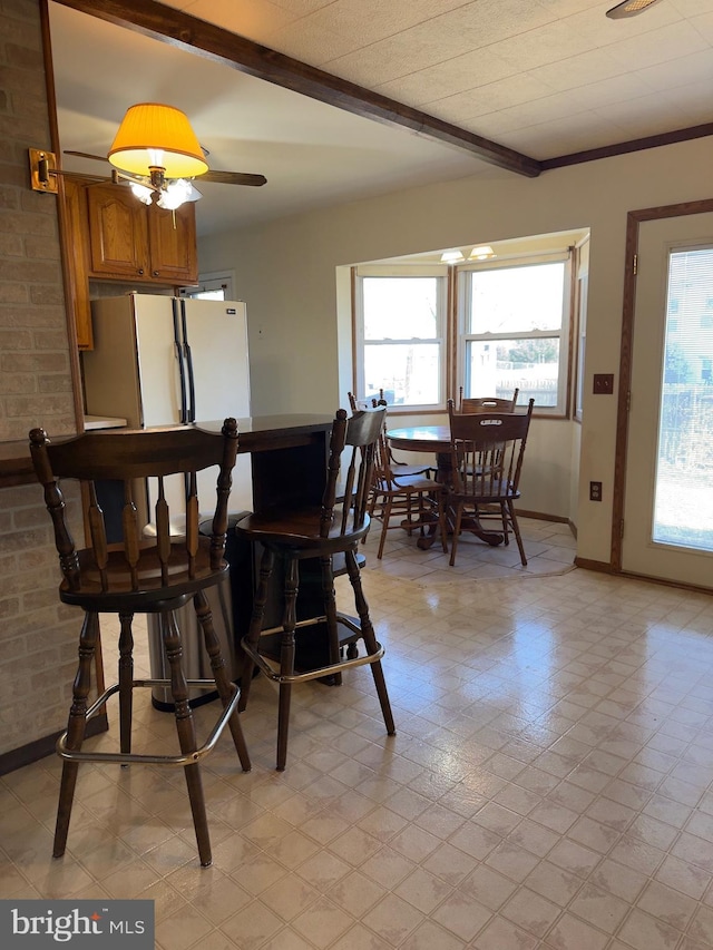 dining area with beam ceiling and baseboards