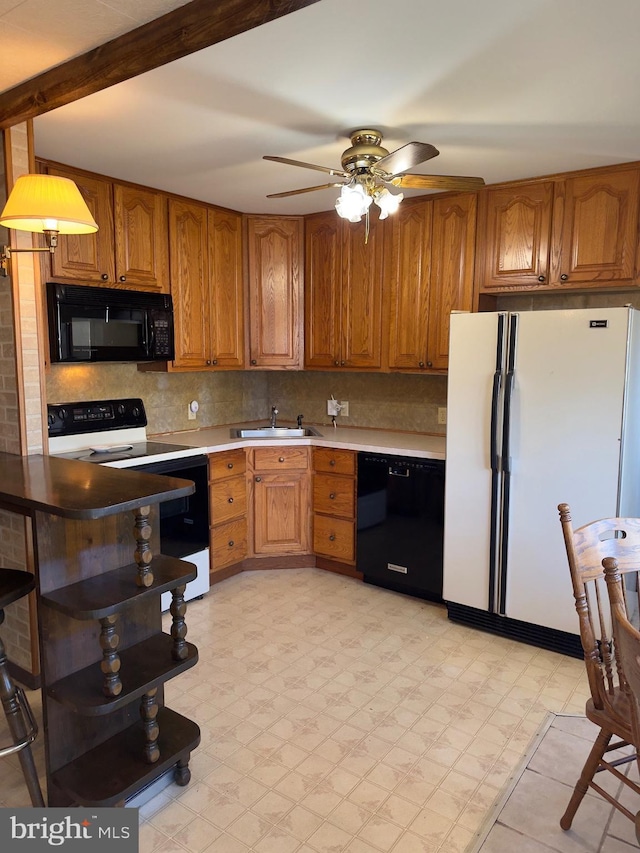 kitchen featuring open shelves, light countertops, brown cabinetry, a sink, and black appliances