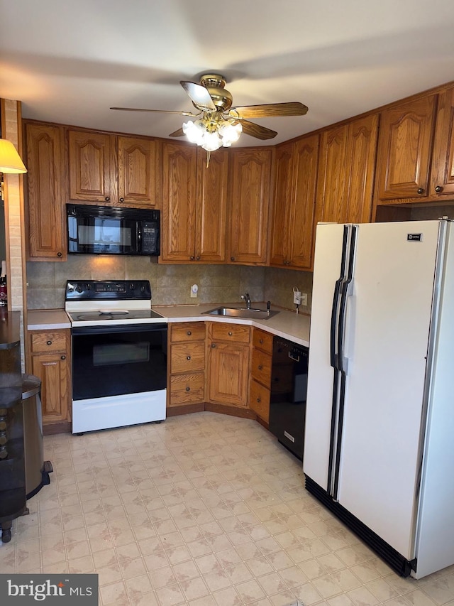 kitchen featuring a sink, black appliances, light countertops, and brown cabinets