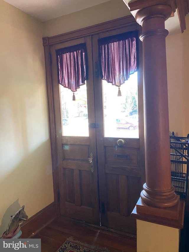 entryway with french doors, ornate columns, plenty of natural light, and dark wood-type flooring