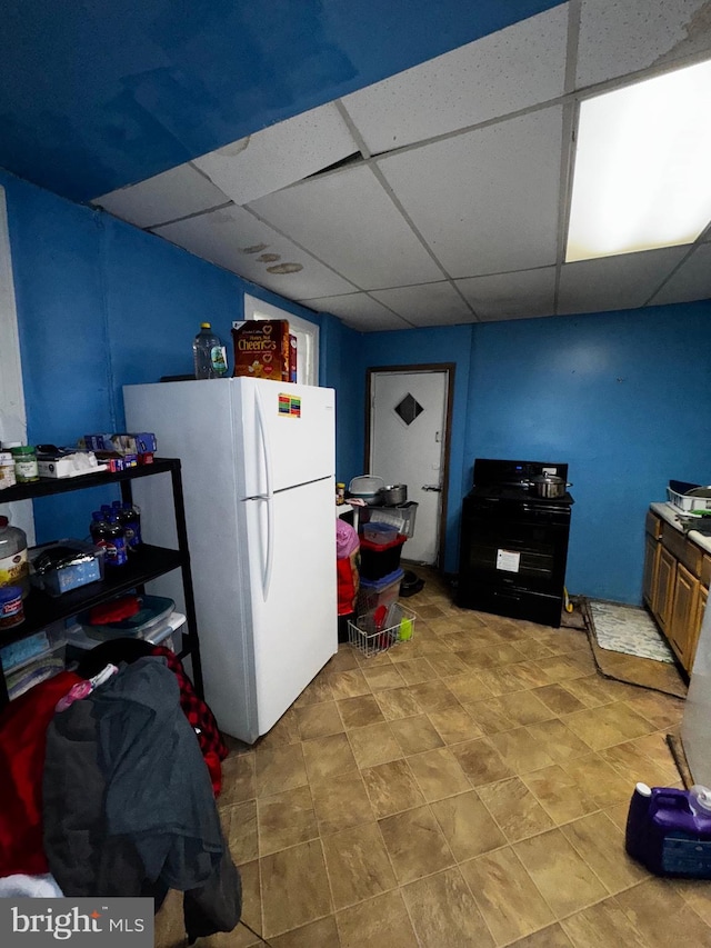 kitchen with a drop ceiling, black electric range, and white fridge