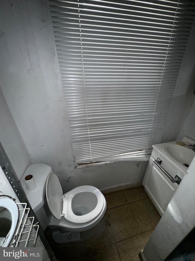 bathroom with toilet, tile patterned floors, and vanity