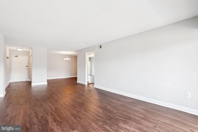 unfurnished room with dark hardwood / wood-style floors and a chandelier