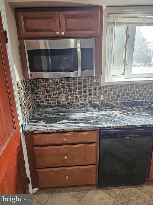 kitchen with decorative backsplash, dark stone counters, and black dishwasher