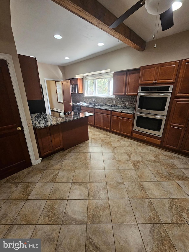 kitchen featuring stainless steel appliances, dark stone counters, tasteful backsplash, light tile patterned floors, and beam ceiling