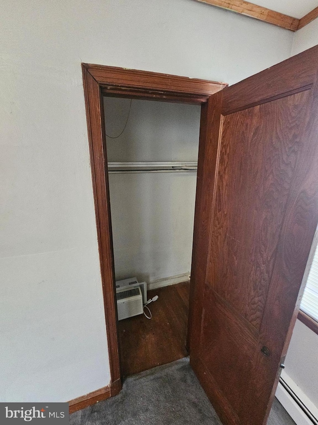 closet with an AC wall unit and a baseboard heating unit