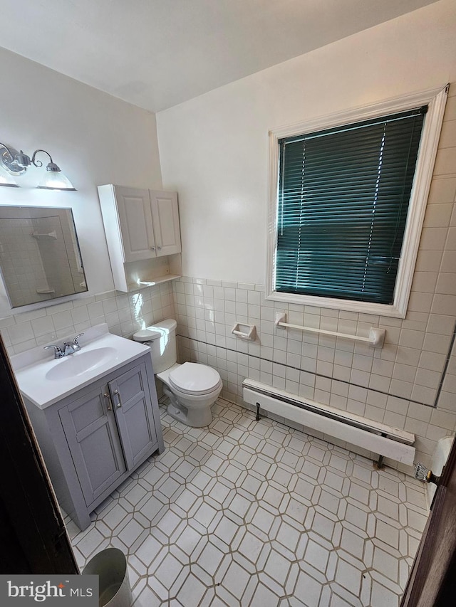 bathroom featuring a baseboard radiator, tile patterned floors, vanity, tile walls, and toilet