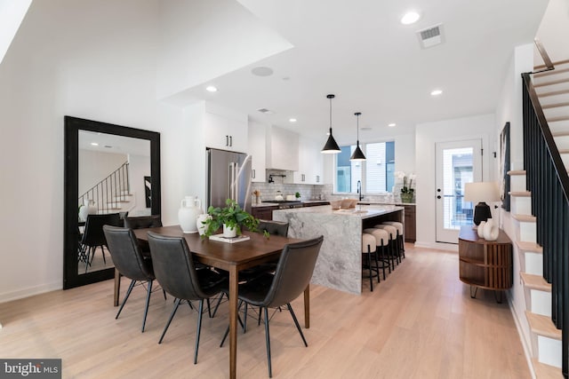 dining room featuring light wood-type flooring and sink