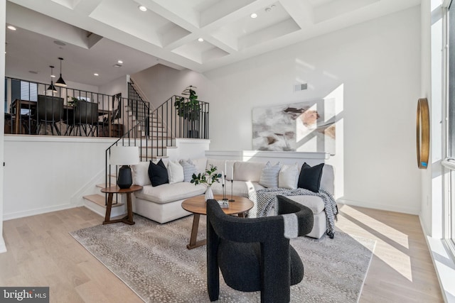 living room with light wood-type flooring, beam ceiling, and coffered ceiling