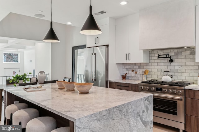 kitchen featuring pendant lighting, white cabinetry, appliances with stainless steel finishes, and a kitchen island