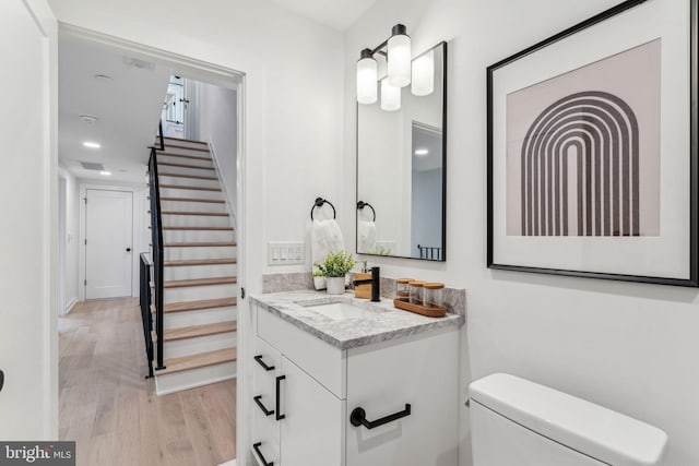 bathroom featuring toilet, vanity, and hardwood / wood-style flooring