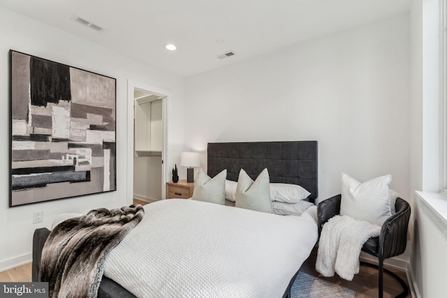 bedroom featuring a closet, a spacious closet, and hardwood / wood-style flooring