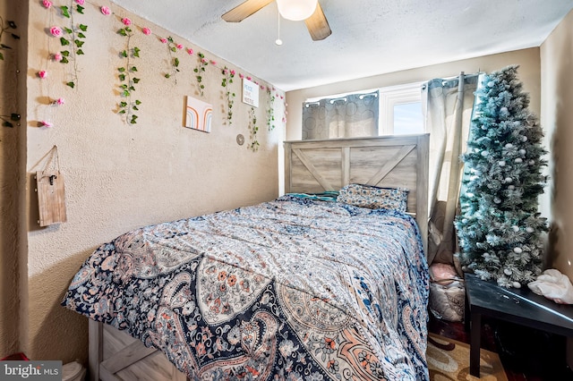 bedroom with ceiling fan and a textured ceiling