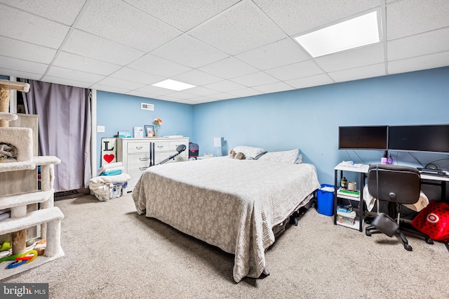 carpeted bedroom with a paneled ceiling