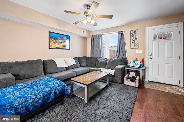 living room with dark wood-type flooring and ceiling fan