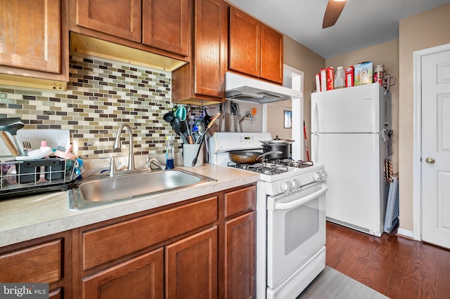 kitchen with sink, white appliances, ceiling fan, dark hardwood / wood-style floors, and tasteful backsplash