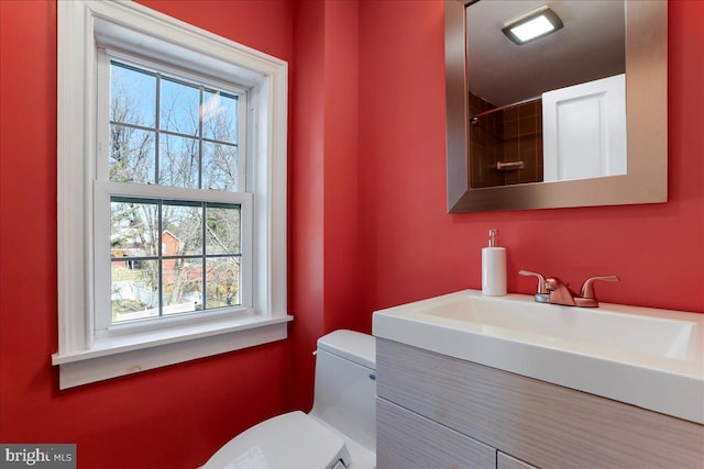 bathroom with vanity, toilet, and a healthy amount of sunlight