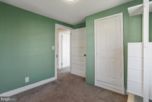 unfurnished bedroom with baseboards and carpet