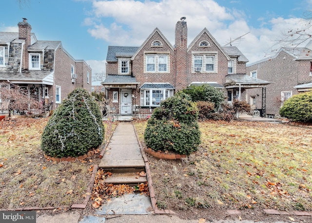 view of front of home featuring brick siding and a chimney