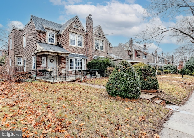 view of front of house featuring brick siding, a front lawn, and a residential view