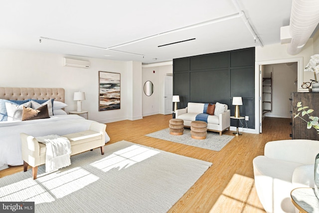 bedroom with hardwood / wood-style floors and a wall mounted AC