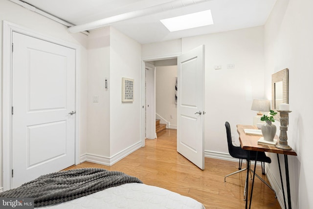 bedroom featuring wood-type flooring and a skylight