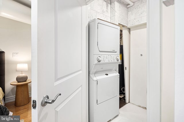 laundry area featuring light wood-type flooring and stacked washer and dryer