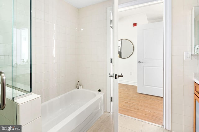 bathroom with tile patterned floors, vanity, and shower with separate bathtub