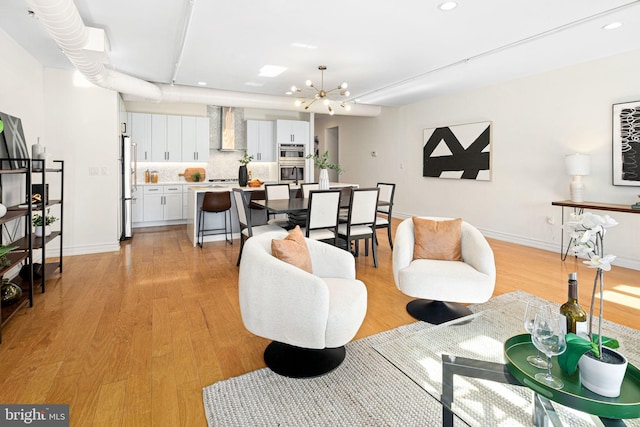 living room featuring light hardwood / wood-style flooring and a notable chandelier