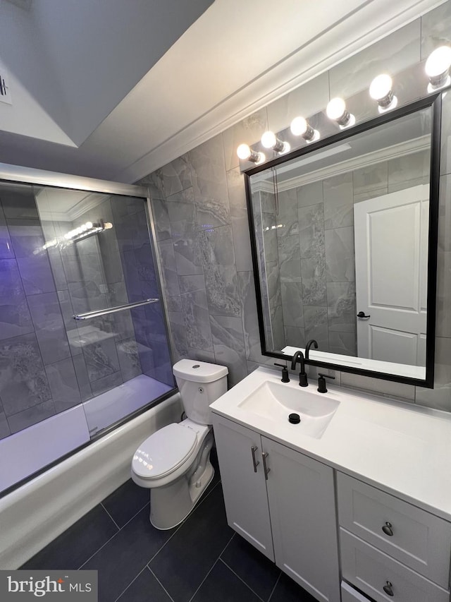 full bathroom featuring enclosed tub / shower combo, tile patterned floors, vanity, tile walls, and toilet