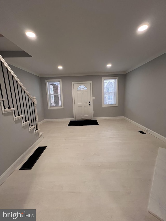 entrance foyer featuring light wood-type flooring and ornamental molding